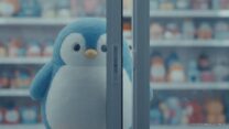 Пингвин Pudgy Penguins на падающей стрелке рядом с монетой PENGU NFT